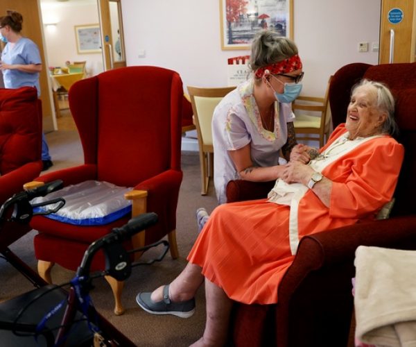 Carer Lucy Skidmore, who remains on site with six colleagues, talks to her 100-year-old great-grandmother and resident Joan Loosley at Fremantle Trust care home, amid the outbreak of the coronavirus disease (COVID-19), in Princes Risborough, Britain, May 5, 2020.   REUTERS/Eddie Keogh